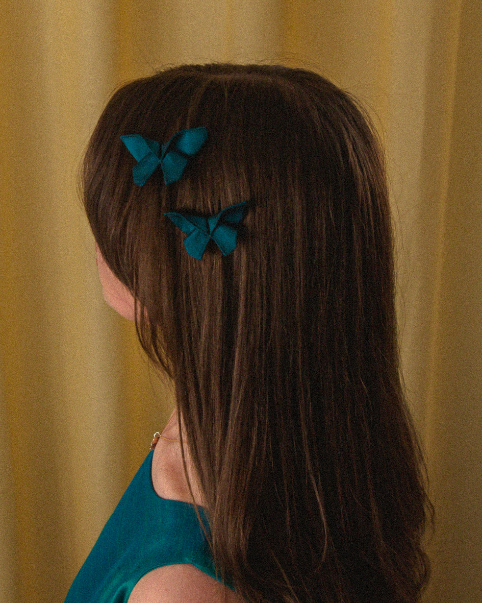 Two Small Origami Silk Butterfly Hair Clips in Dark Teal on model.