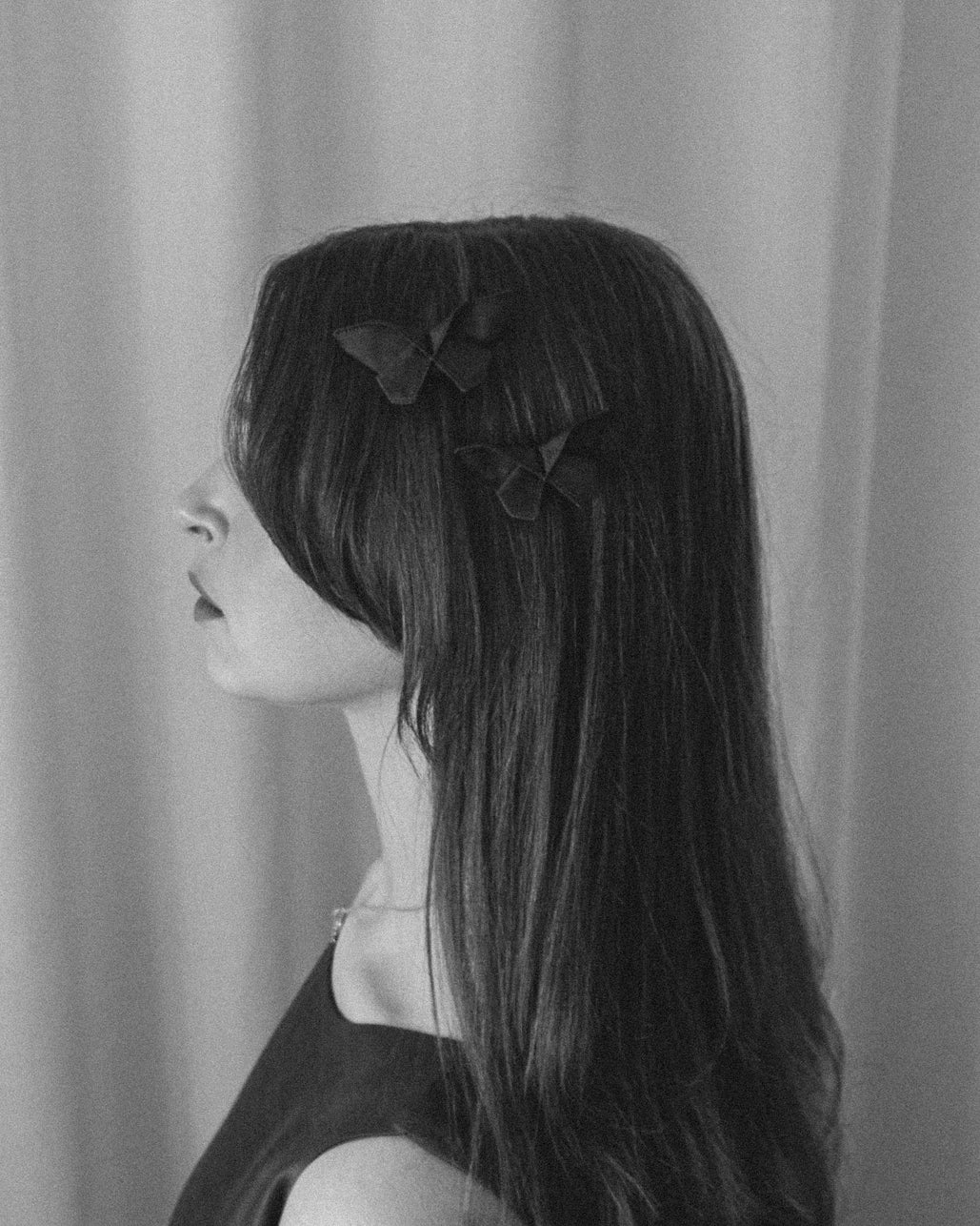 Black and white photo of two small Origami Silk Butterfly Hair Clips on model.