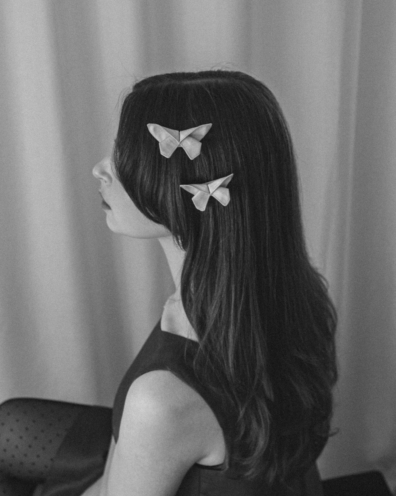 Black and white photo of two small Origami Silk Butterfly Hair Clips on model.