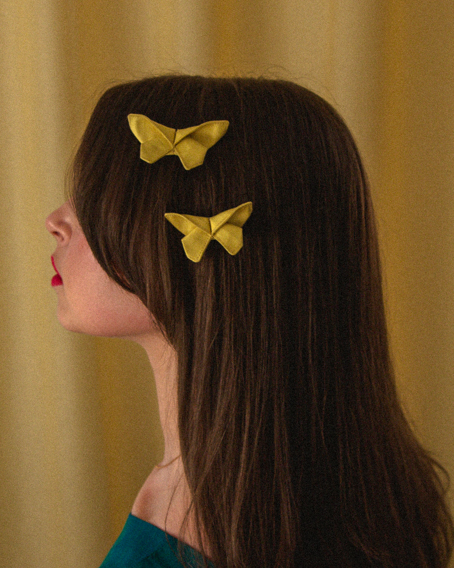 Two Small Origami Silk Butterfly Hair Clips in Butter Yellow on model.