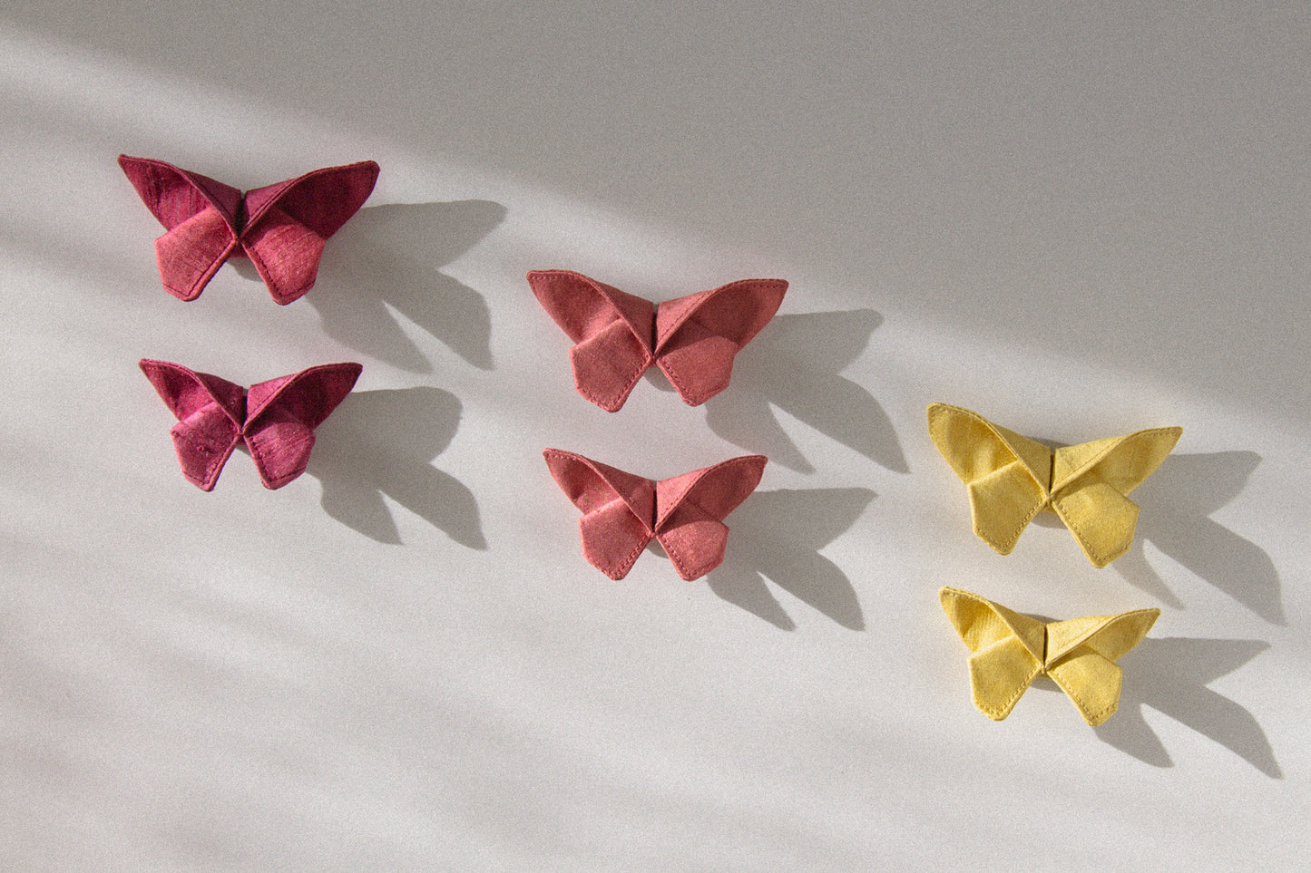 Three of the six colors of the small Origami Silk Butterfly Hair Clips on white background.