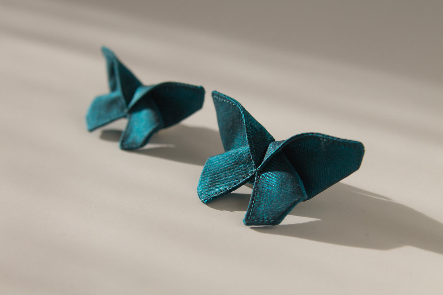 Origami Silk Butterfly Hair Clips in Dark Teal on white background.