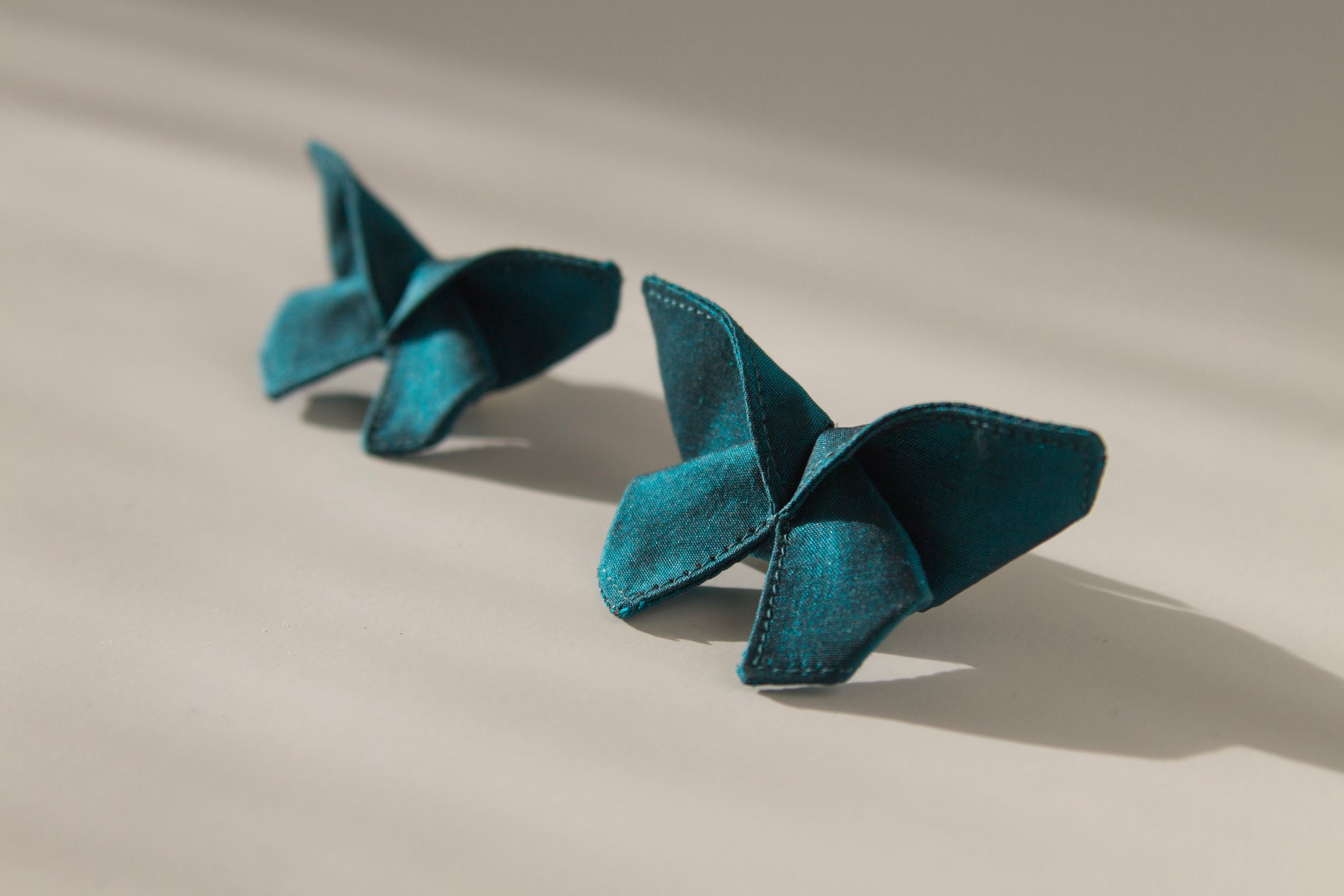 Origami Silk Butterfly Hair Clips in Dark Teal on white background.